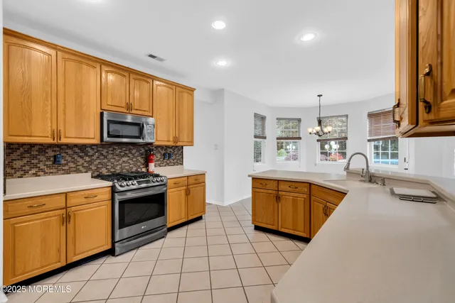 a kitchen with stainless steel appliances granite countertop a stove a sink and a microwave