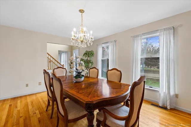 a dining room with furniture a chandelier and wooden floor