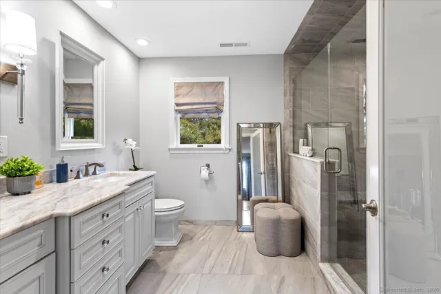 a bathroom with a granite countertop sink toilet and shower