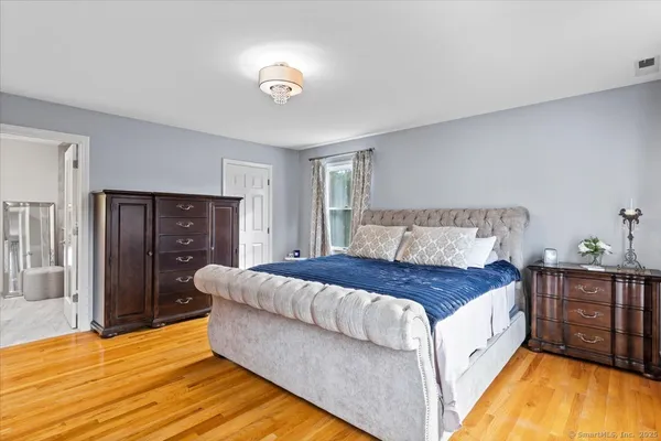 a spacious bedroom with a bed and a dresser