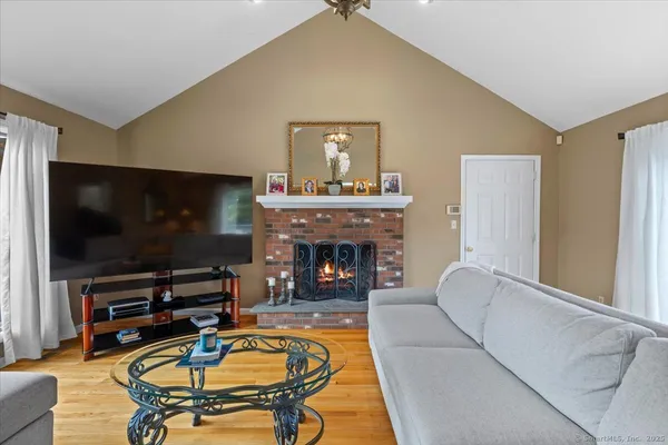 a living room with furniture a flat screen tv and a fireplace
