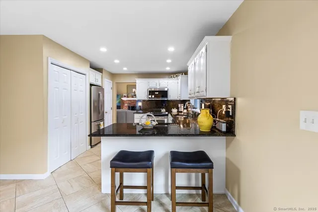 a kitchen with stainless steel appliances granite countertop a refrigerator and a stove top oven