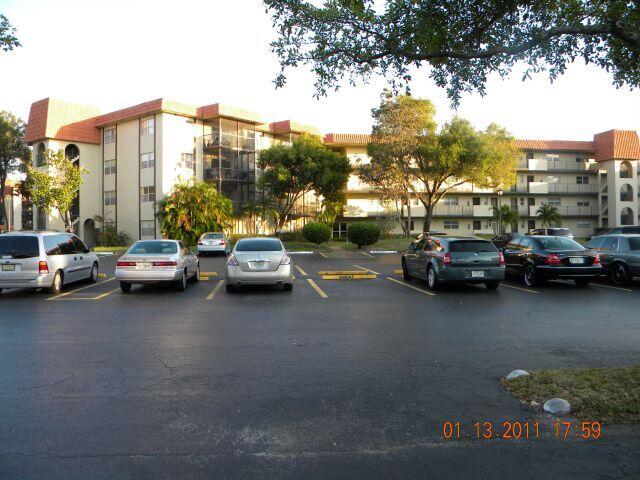 5961 North Falls Cir Drive, Unit 306 Lauderhill, FL 33319 - Photo 2 of 16 a view of a city street with cars parked