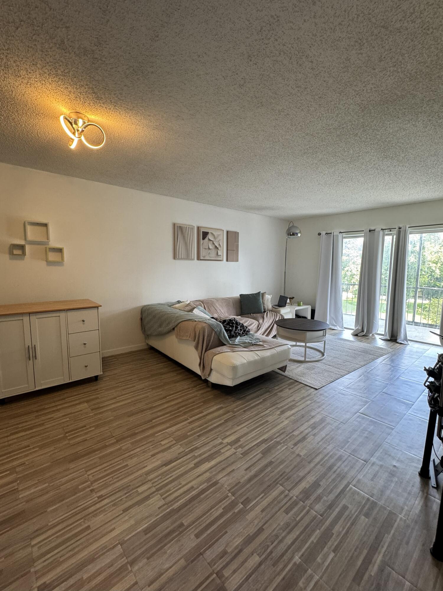 5961 North Falls Cir Drive, Unit 306 Lauderhill, FL 33319 - Photo 8 of 16 a living room with furniture and a wooden floor