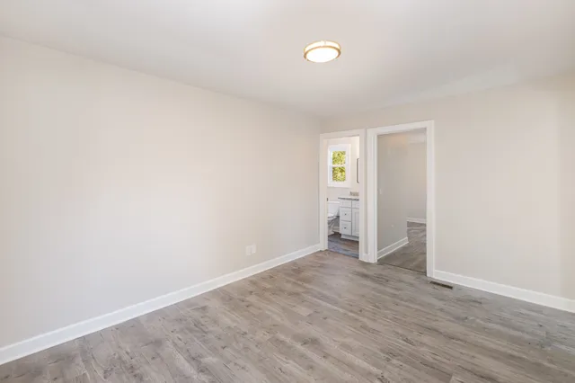 an empty room with wooden floor and closet