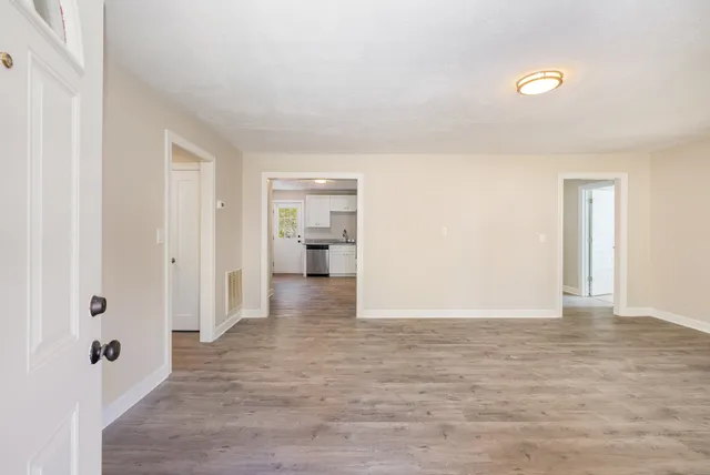 a view of a livingroom with wooden floor and bathroom