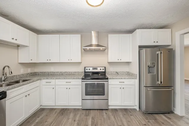 a kitchen with a stove top oven and refrigerator