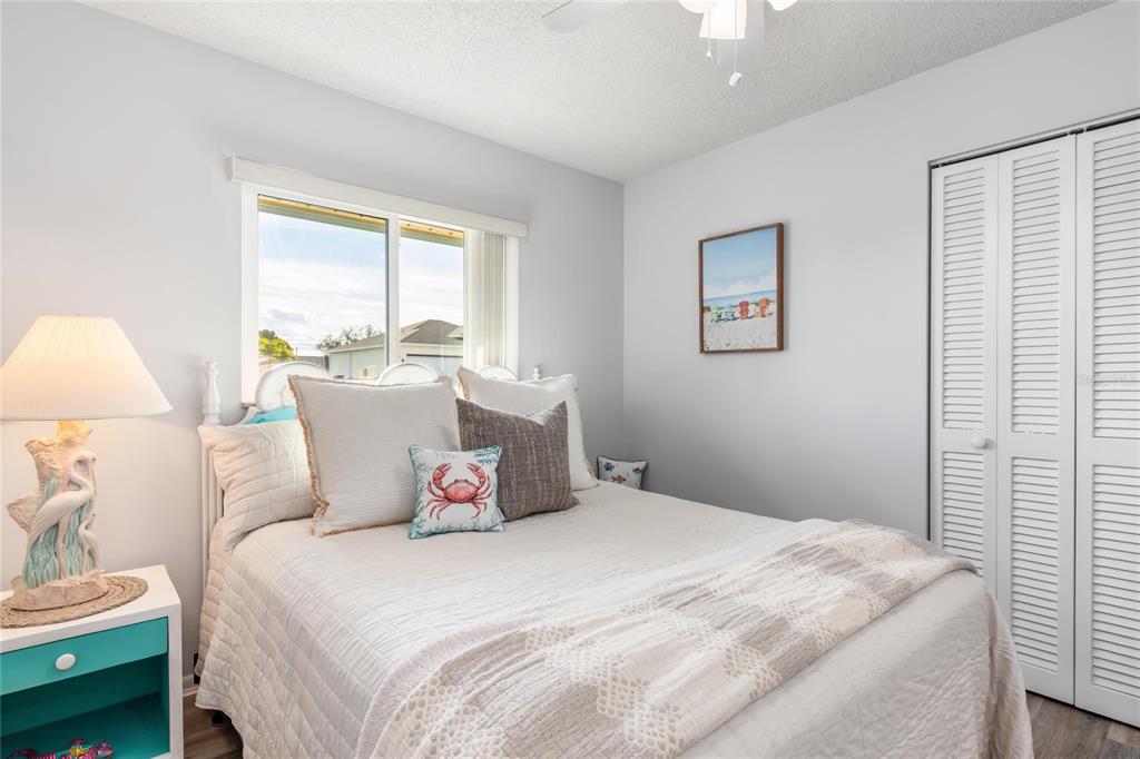 774 Spring Lake Boulevard Northwest Port Charlotte, FL 33952 - Photo 18 of 29 a bedroom with a large bed and a lamp on table next to a window