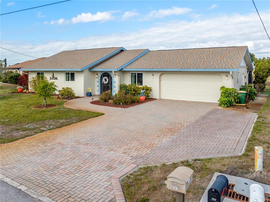 774 Spring Lake Boulevard Northwest Port Charlotte, FL 33952 - Photo 22 of 29 a front view of a house with a yard and garage
