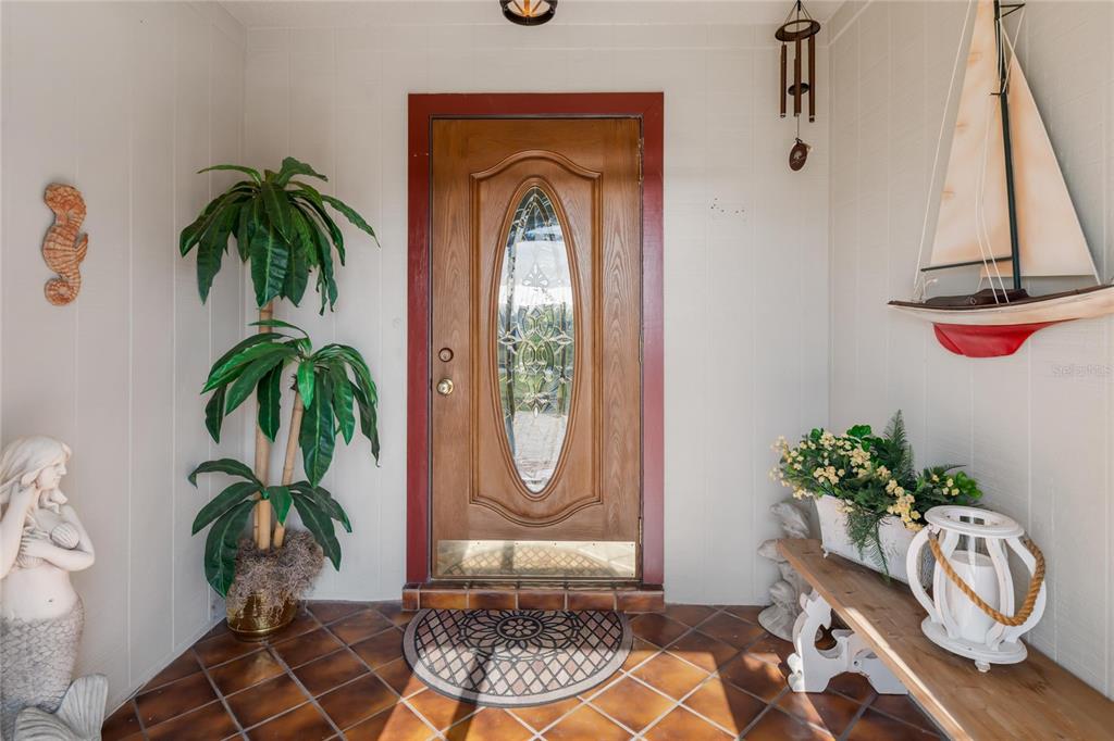 774 Spring Lake Boulevard Northwest Port Charlotte, FL 33952 - Photo 3 of 29 a vase of flowers sitting on a table with a potted plant
