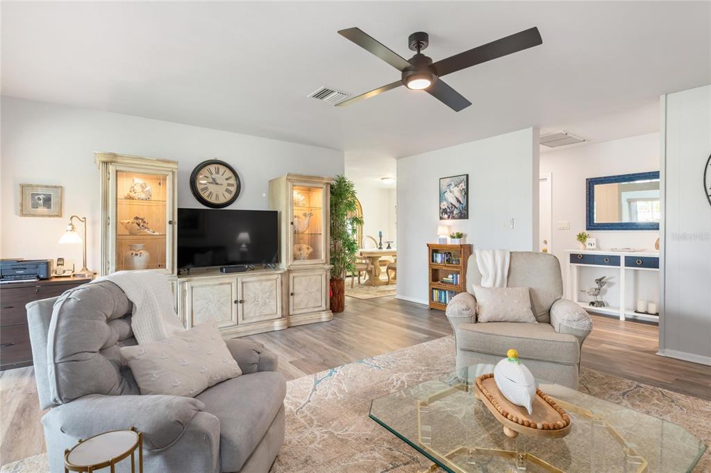 774 Spring Lake Boulevard Northwest Port Charlotte, FL 33952 - Photo 6 of 29 a living room with furniture a clock and wooden floor
