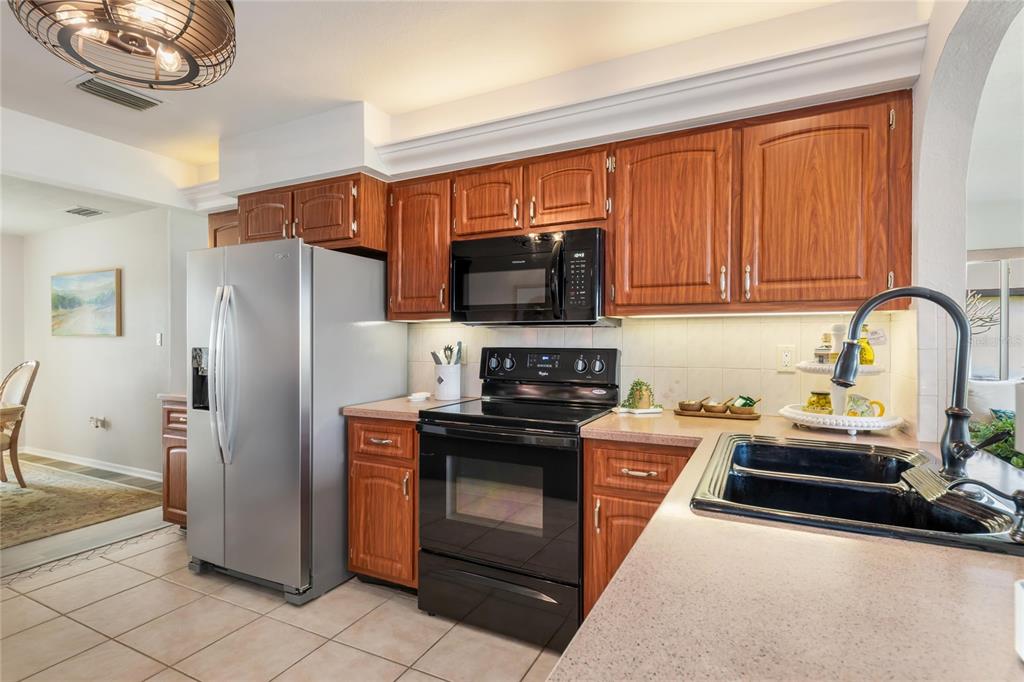 774 Spring Lake Boulevard Northwest Port Charlotte, FL 33952 - Photo 9 of 29 a kitchen with stainless steel appliances granite countertop a refrigerator stove and sink