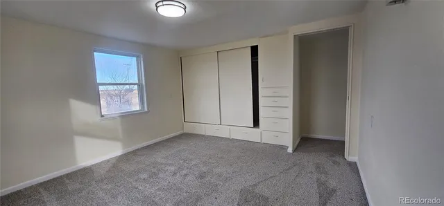 an empty room with windows and closet
