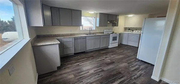 a kitchen with a sink a refrigerator and window