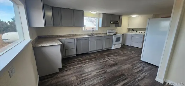 a kitchen with a sink a refrigerator and window