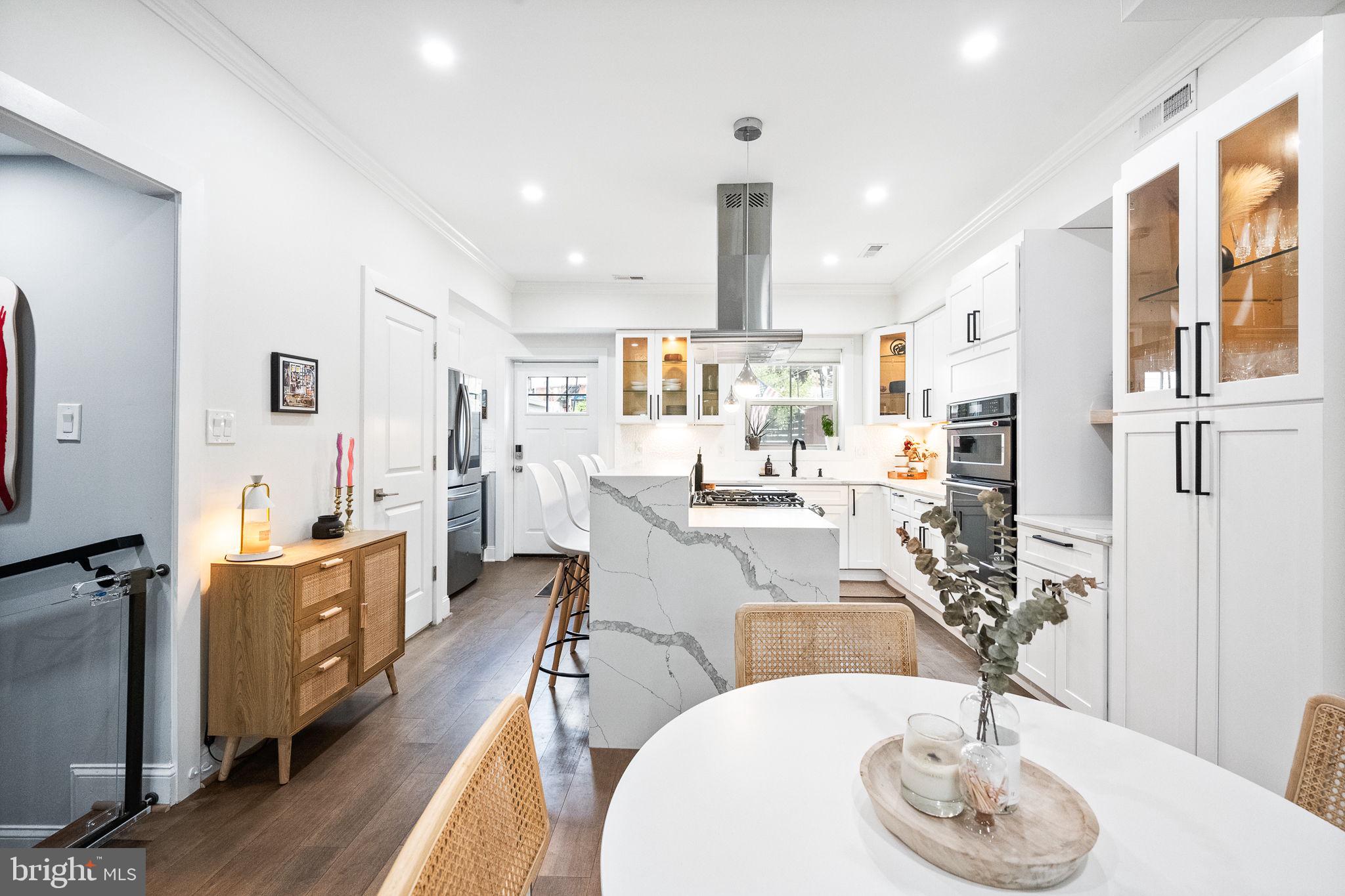 4625 4th Street Northwest Washington, DC 20011 - Photo 8 of 41 a kitchen with stainless steel appliances kitchen island granite countertop a table chairs and a wooden floor
