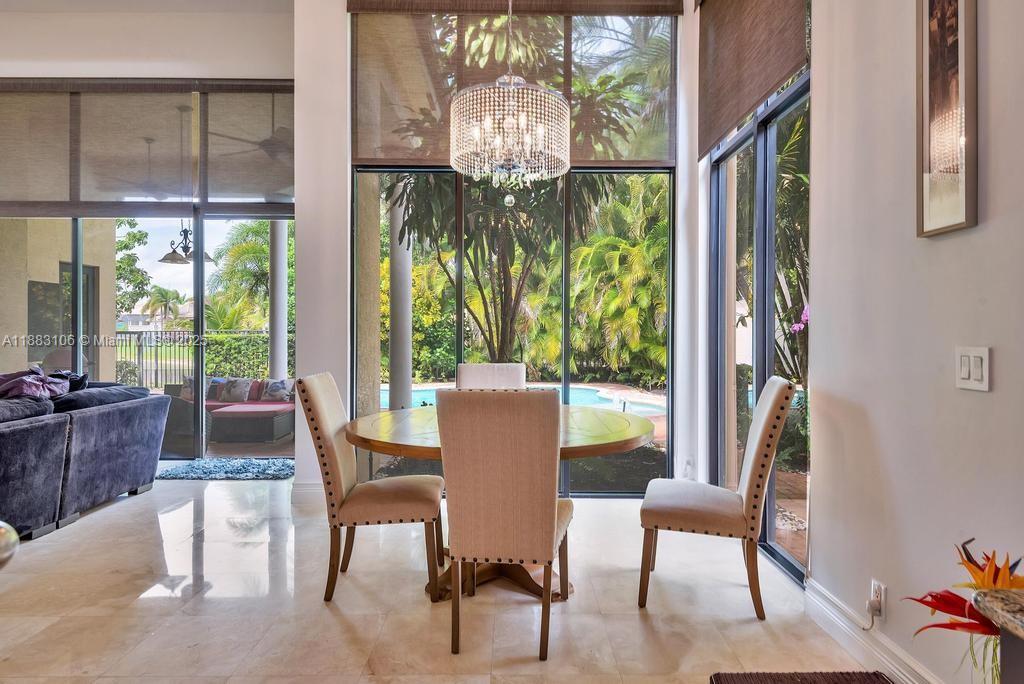 17931 Lake Azure Way Boca Raton, FL 33496 - Photo 18 of 59 a view of a dining room with furniture a chandelier and wooden floor