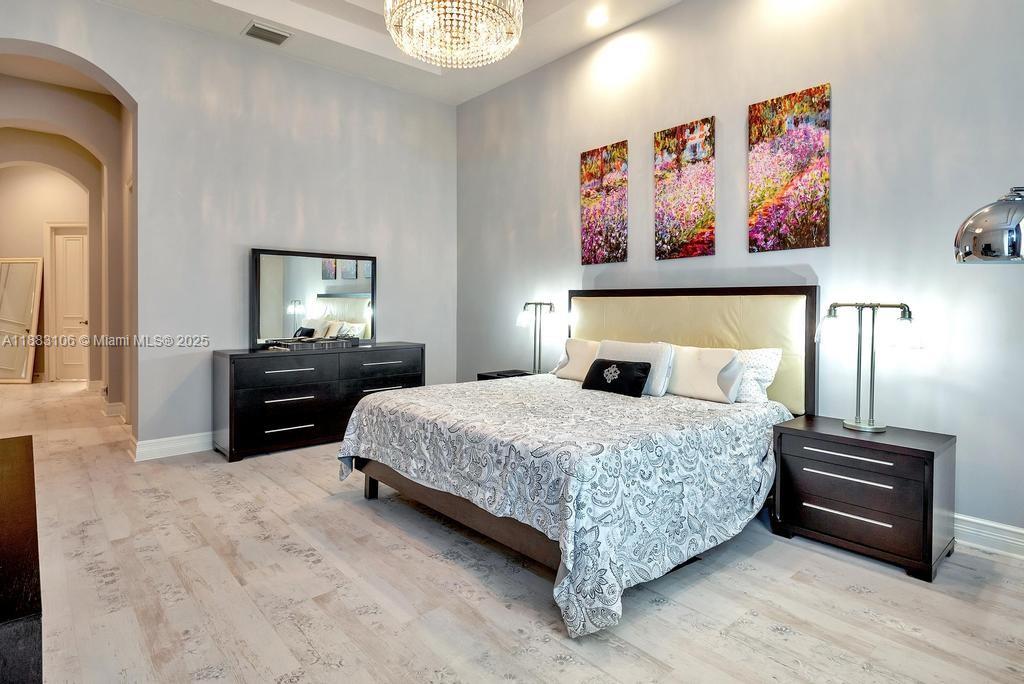 17931 Lake Azure Way Boca Raton, FL 33496 - Photo 22 of 59 a bedroom with a bed and a chandelier