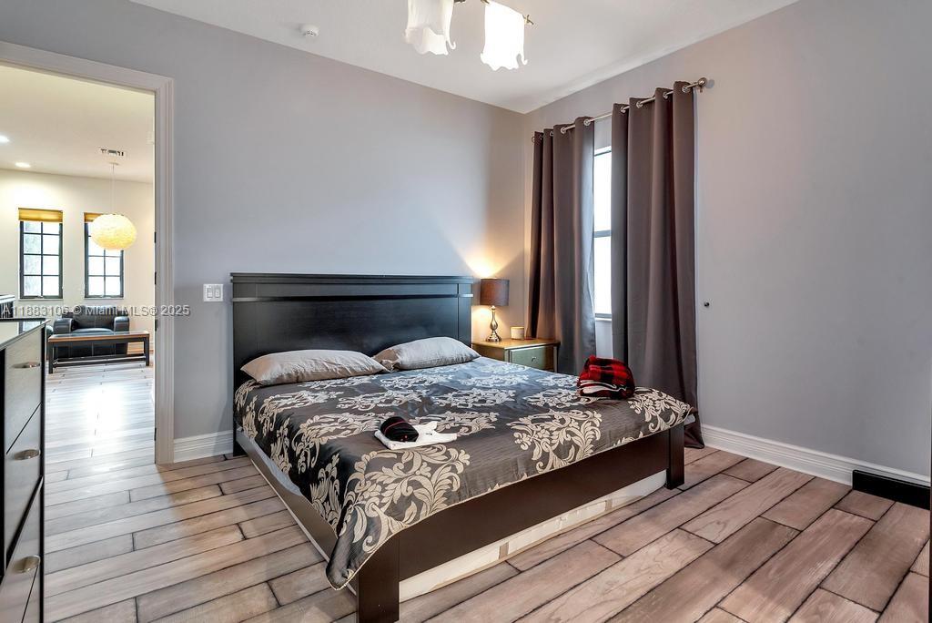 17931 Lake Azure Way Boca Raton, FL 33496 - Photo 35 of 59 a bedroom with a bed and wooden floor