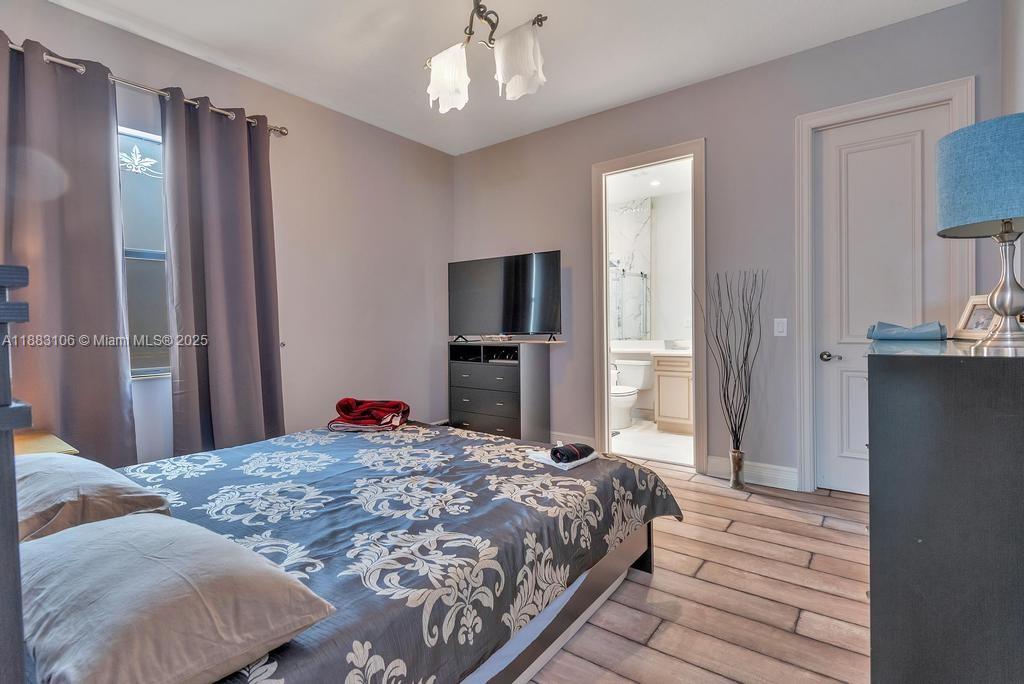 17931 Lake Azure Way Boca Raton, FL 33496 - Photo 36 of 59 a bedroom with a large bed and a chandelier