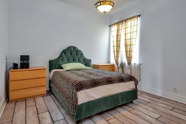 a bedroom with a bed dresser and a window