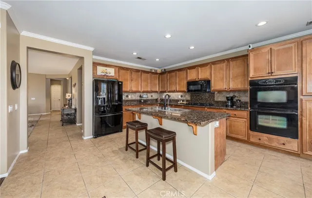 a kitchen with stainless steel appliances granite countertop a refrigerator and a stove top oven
