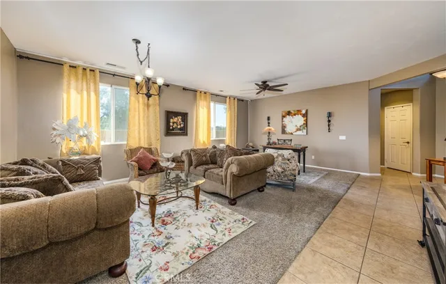 a living room with furniture hard wood floor and a chandelier