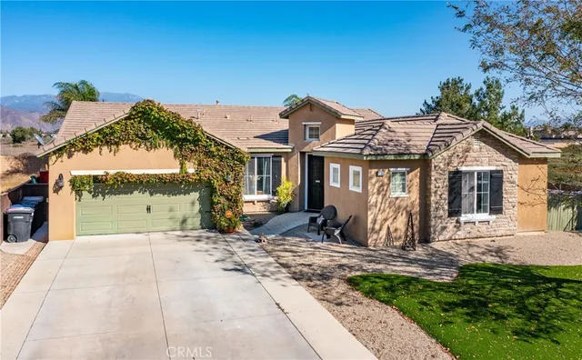 a front view of a house with a garden and yard
