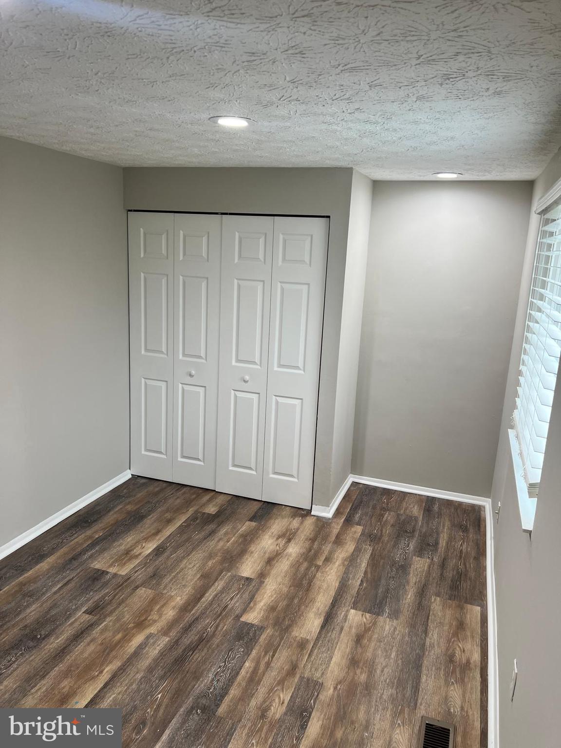 13965 Palmer House Way, Unit 27195 Silver Spring, MD 20904 - Photo 11 of 16 an empty room with wooden floor and closet