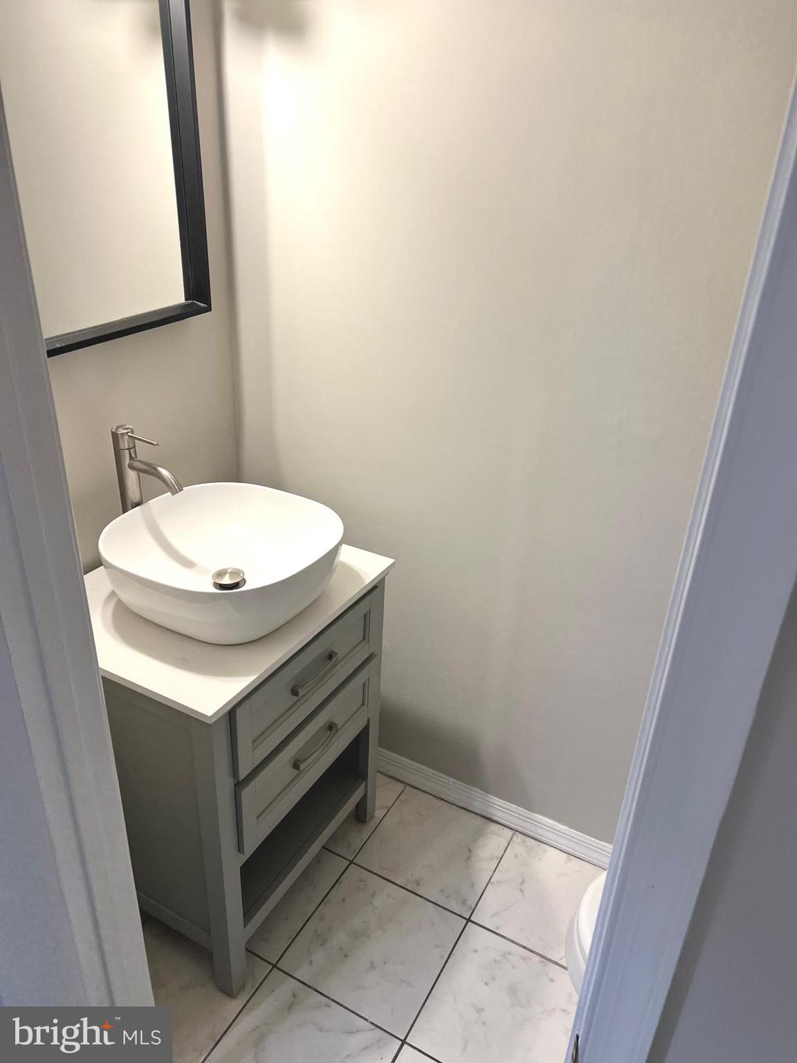 13965 Palmer House Way, Unit 27195 Silver Spring, MD 20904 - Photo 13 of 16 a bathroom with a sink a toilet and mirror