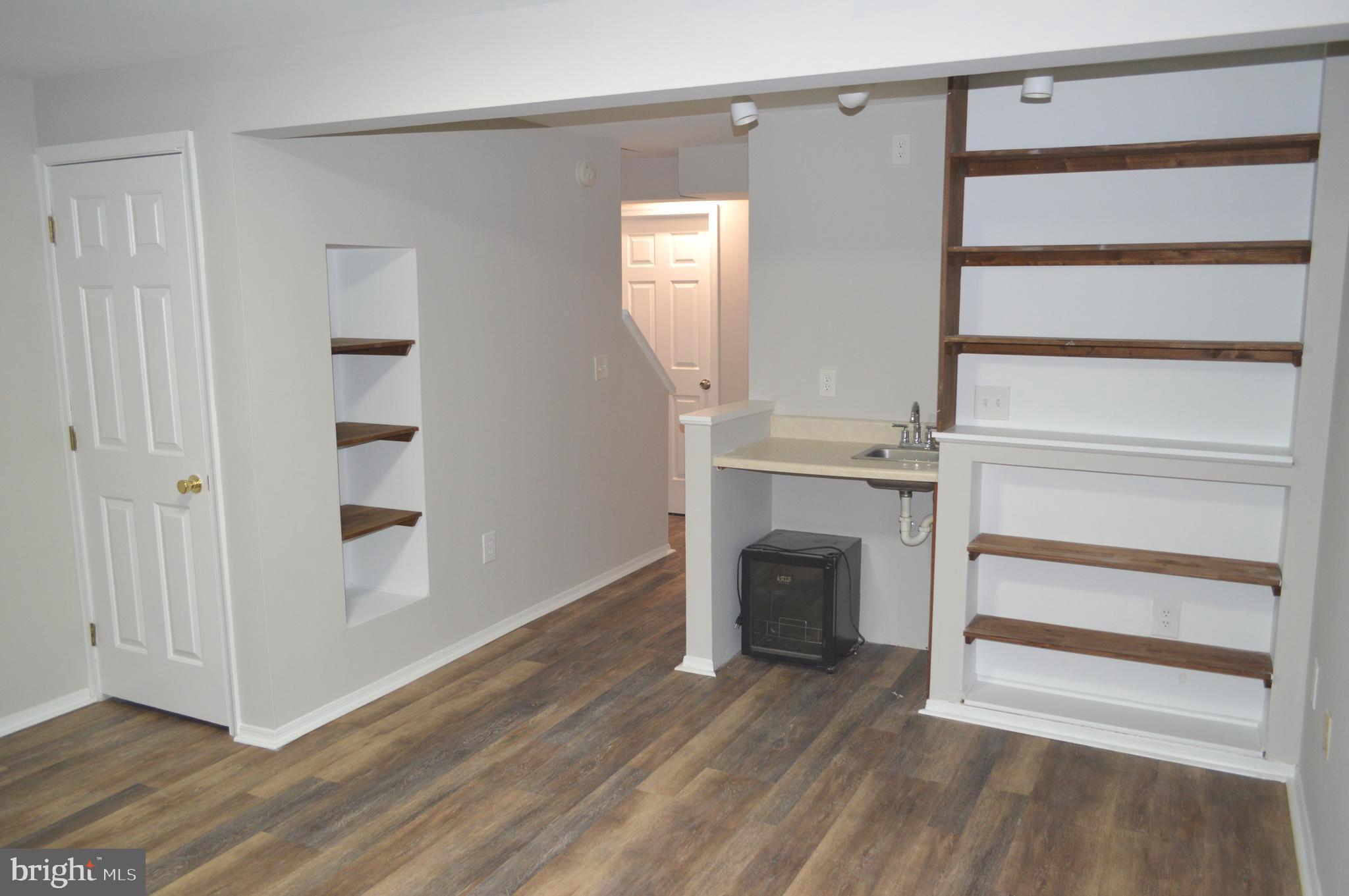 13965 Palmer House Way, Unit 27195 Silver Spring, MD 20904 - Photo 14 of 16 a view of an empty room with wooden floor and a window