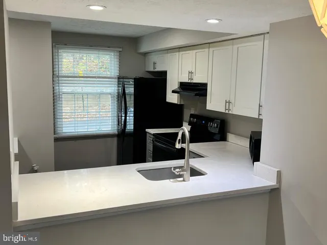a kitchen with a sink a refrigerator and cabinets