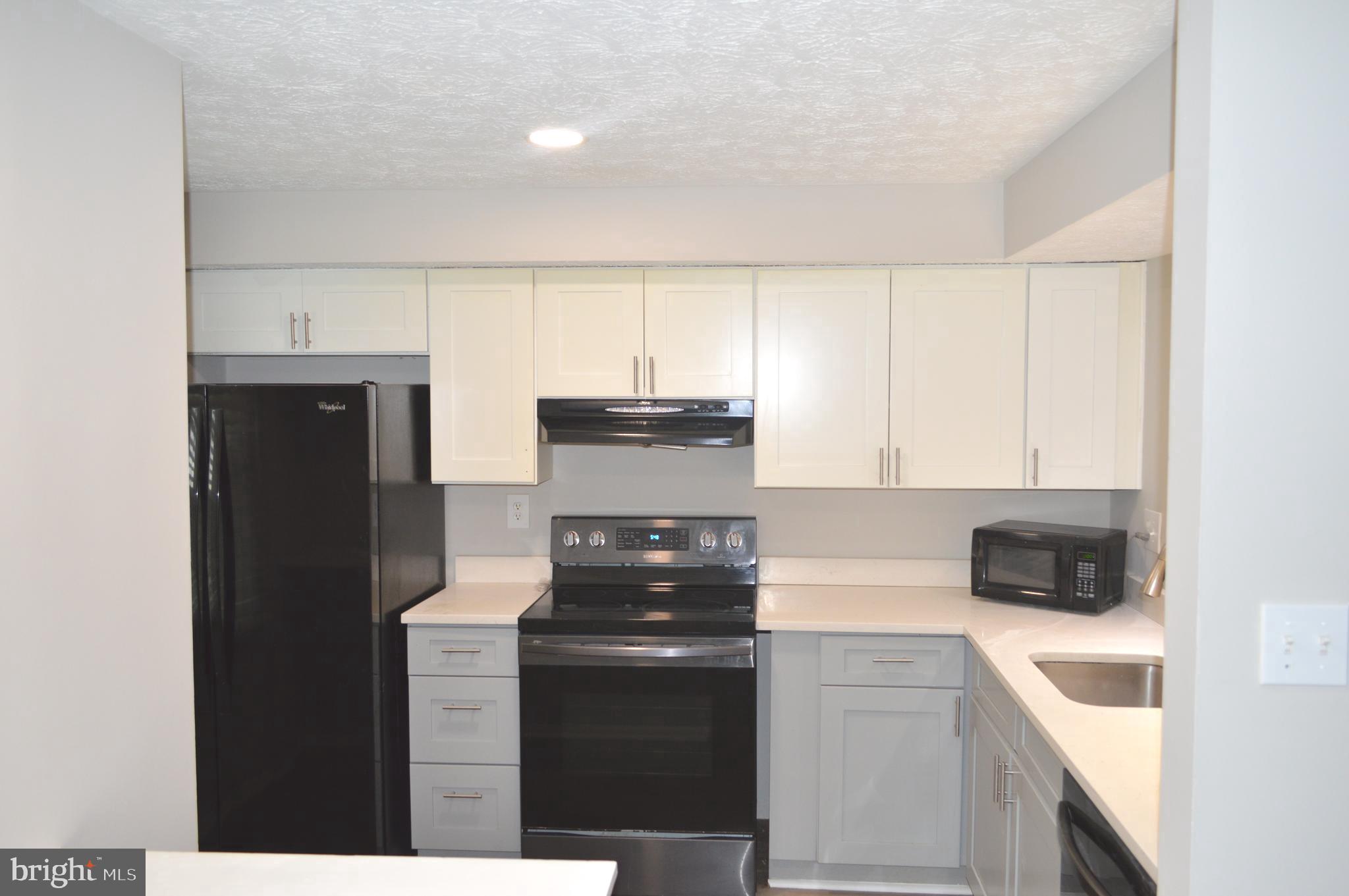 13965 Palmer House Way, Unit 27195 Silver Spring, MD 20904 - Photo 5 of 16 a kitchen with a refrigerator stove and microwave