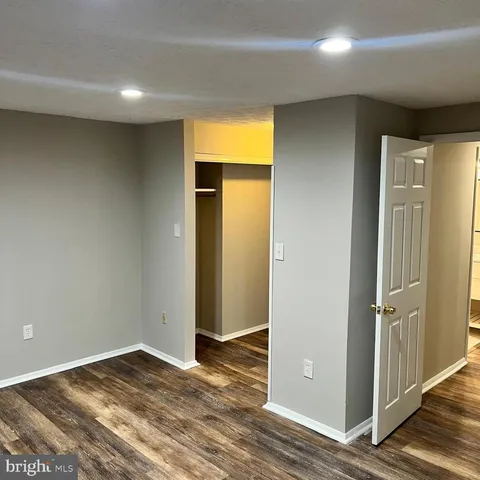 an empty room with wooden floor and closet
