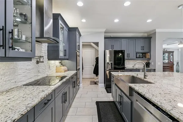 a large kitchen with granite countertop kitchen island a sink stove and refrigerator
