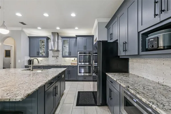 a kitchen with stainless steel appliances granite countertop a sink stove and refrigerator