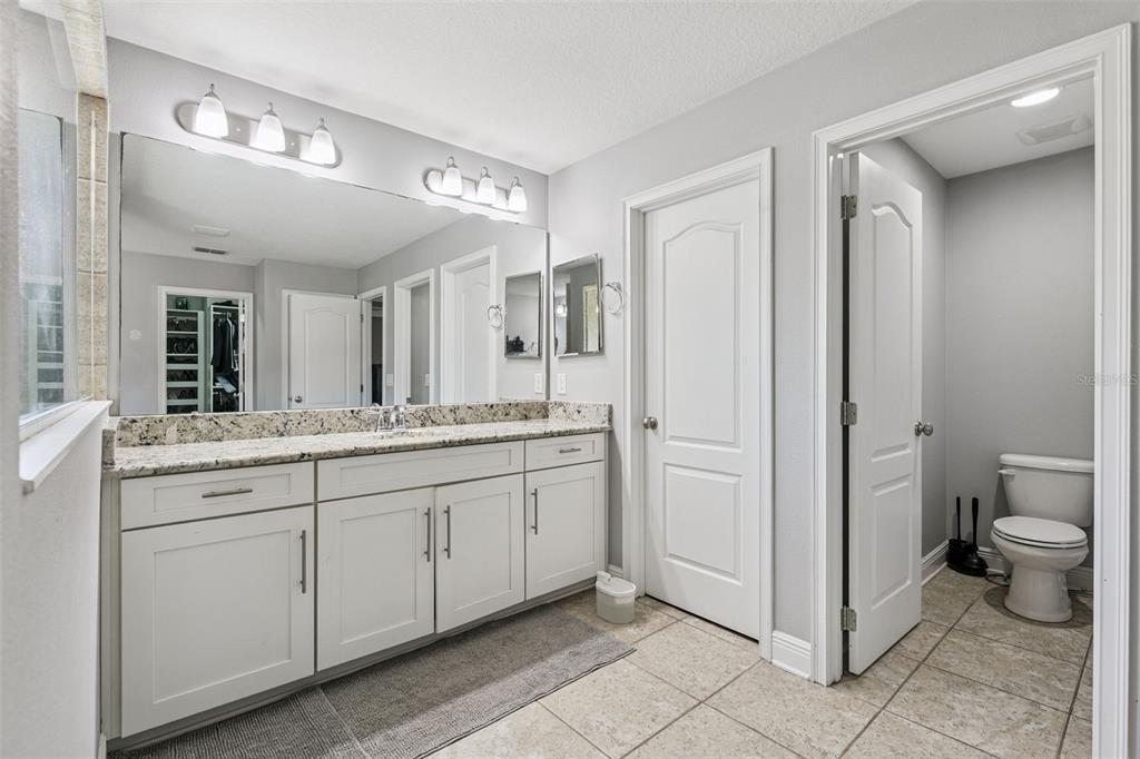 2541 Red Berry Way Ocoee, FL 34761 - Photo 25 of 49 a bathroom with a granite countertop sink mirror and toilet