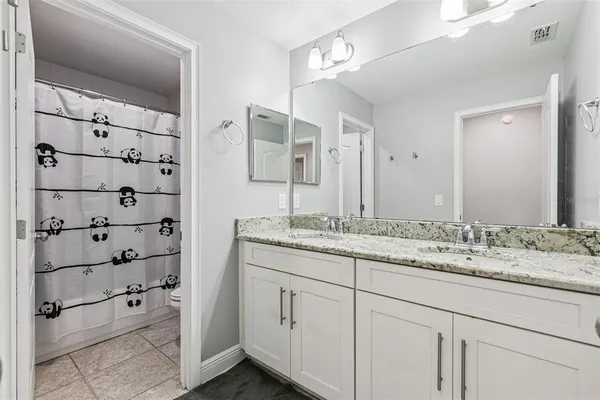 a bathroom with a granite countertop sink and a mirror