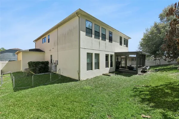 a view of swimming pool with outdoor seating and house in the background