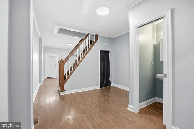a view of a hallway with entryway with wooden floor