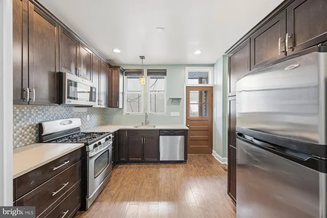 a kitchen with stainless steel appliances granite countertop a stove a sink and a refrigerator