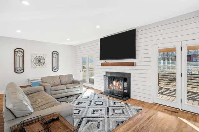 a living room with furniture a flat screen tv and a fireplace