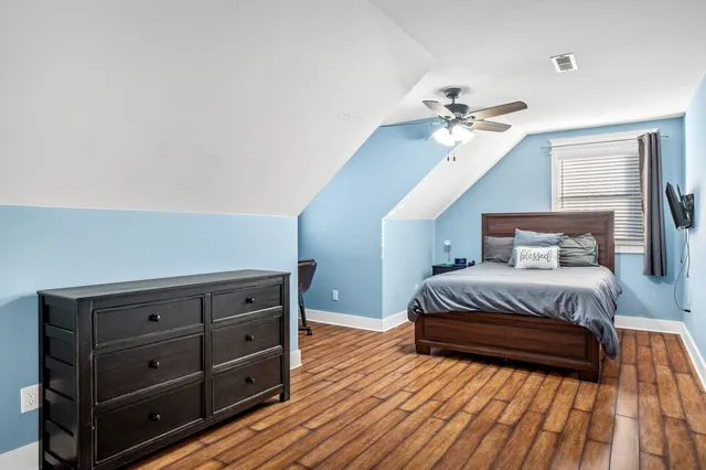a bedroom with a bed and wooden floor