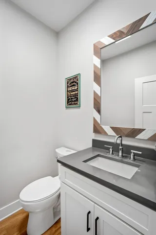 a bathroom with a granite countertop toilet sink and mirror