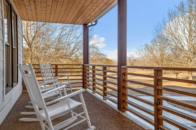 a view of a balcony with wooden floor and outdoor seating