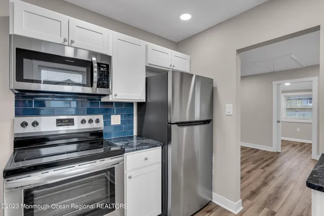 a kitchen with appliances a refrigerator and cabinets