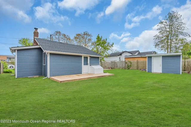a view of a house with a yard and large tree