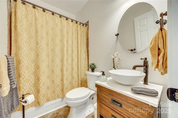 a bathroom with a sink a toilet and a mirror