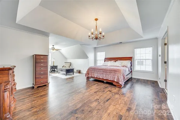 a bedroom with bed and wooden floor