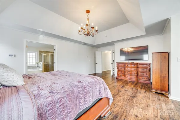 a spacious bedroom with a bed and a flat screen tv